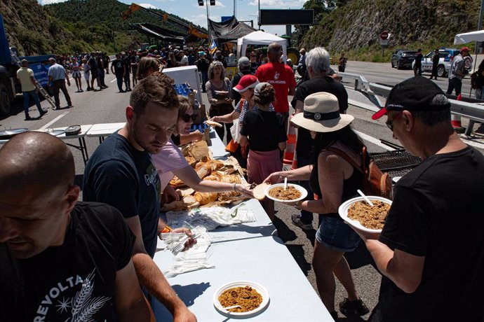 Los manifestantes comen durante una protesta en la autopista AP7 a la altura de Le Perthus, en la frontera entre España y Francia, a 3 de junio de 2024, en Le Perthus (Francia). Las protestas de los agricultores de España y Francia han vuelto a cortar car