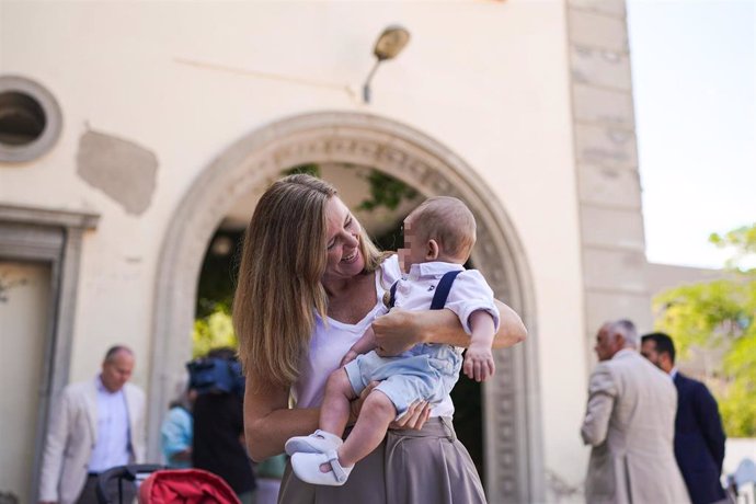 La consejera de Familia, Juventud y Asuntos Sociales, Ana Dávila, sostiene en brazos a un bebé en acogida en la residencia infantil El Encinar de Madrid.