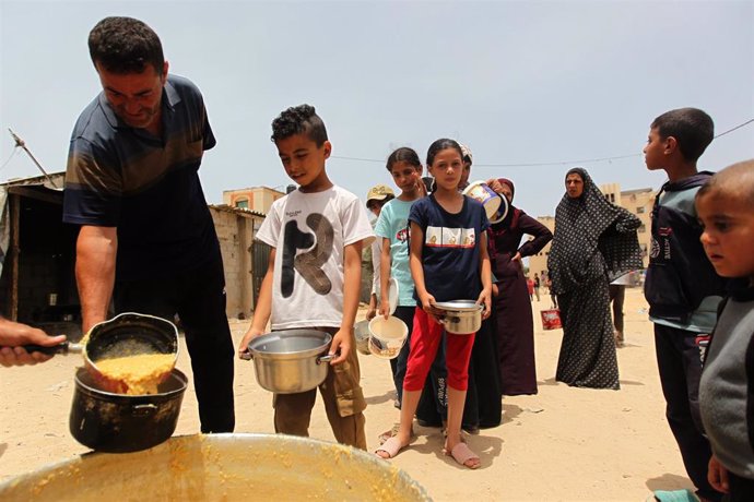 Población gazatí haciendo cola para recibir alimentos en Rafá.