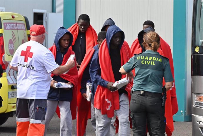 Archivo - Los equipos sanitarios atienden a varios migrantes en una llegada a un puerto de Canarias