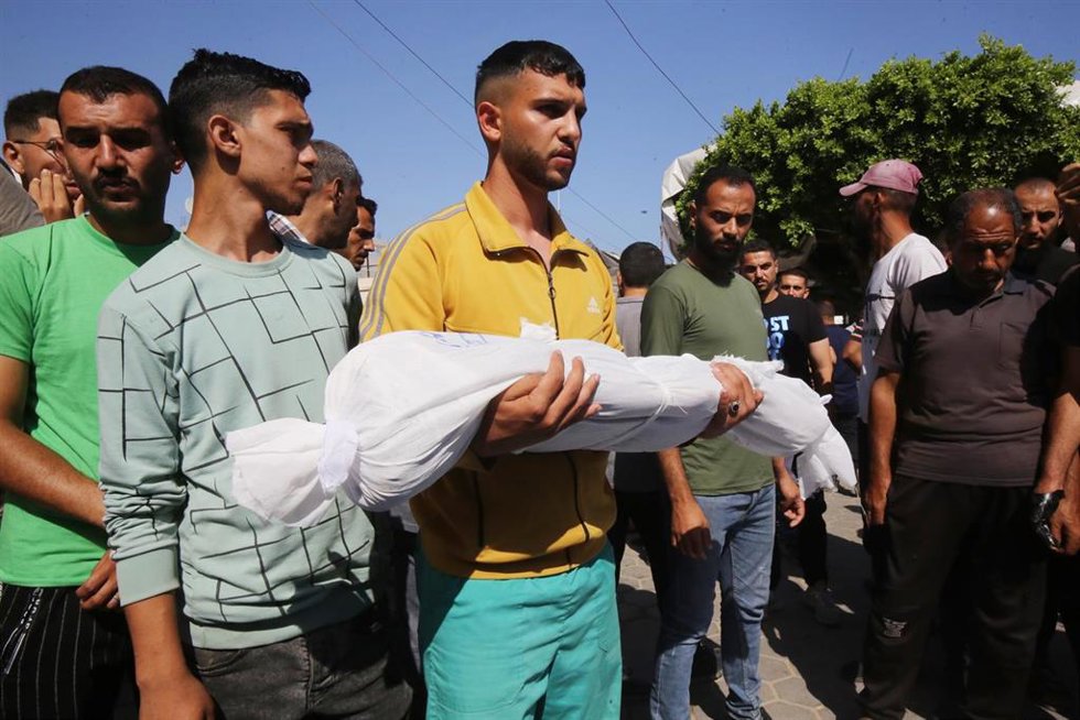 Un joven sostiene el cuerpo de uno de sus familiares muerto por los ataques de Israel.