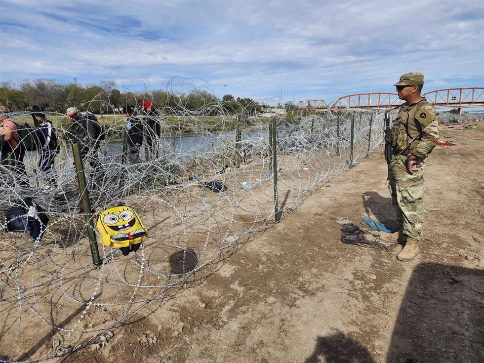 Archivo - Guardia fronterizo estadounidense en una valla junto a la frontera con México