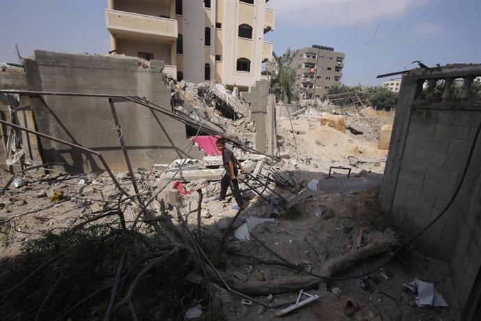 Palestinos entre edificios destruidos por el Ejército de Israel en la ciudad de Deir al Balá, en el centro de la Franja de Gaza (archivo)