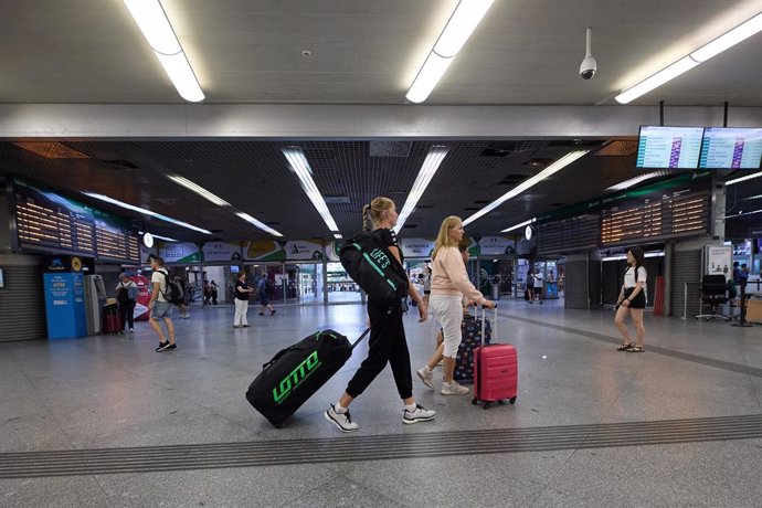 Archivo - Varias personas con maletas caminan por uno de los pasillos de la estación de Atocha-Almudena Grandes con motivo de la operación salida de inicios de agosto, a 28 de julio de 2023, en Madrid (España). L 