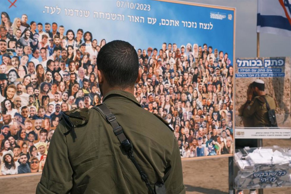 Archivo - Fotografía de archivo de un soldado de Israel frente a un mural en el kibutz Reim en recuerdo de las víctimas de los ataques ejecutados el 7 de octubre por el Movimiento de Resistencia Islámica (Hamás)