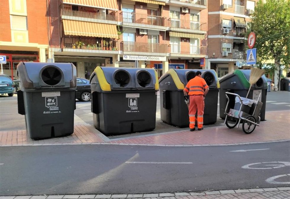 Archivo - Un trabajador de Sadeco junto a unos contenedores, en una imagen de archivo.