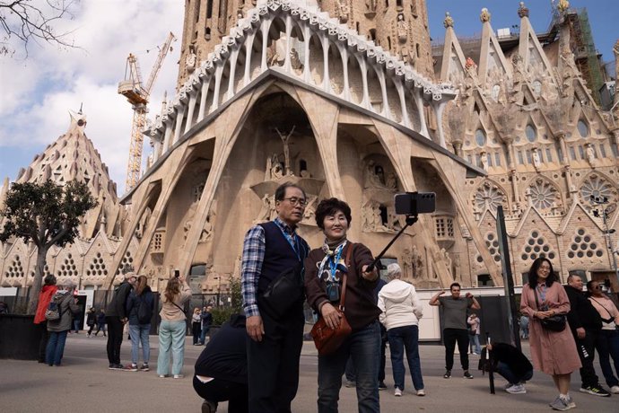 Archivo - Varios turistas se hacen fotos junto a la Sagrada Familia, a 15 de marzo de 2024, en Barcelona, Catalunya (España).