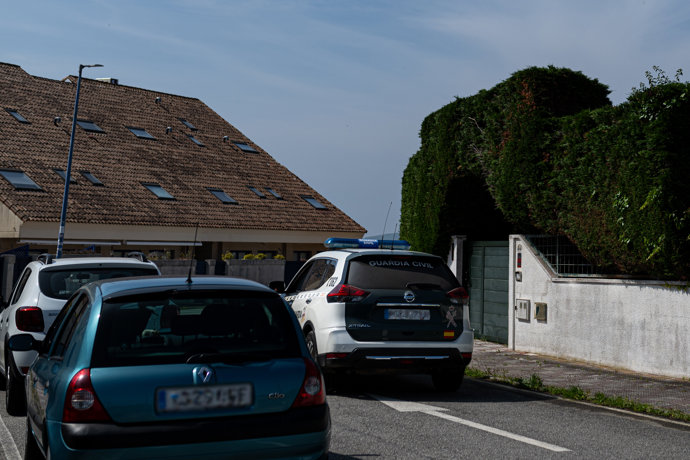 Un coche de la Guardia Civil en la puerta de la vivienda de O Grove (Pontevedra) en la que fueron detenidas dos personas vinculadas a un grupo dedicado supuestamente a estafar a narcotraficantes