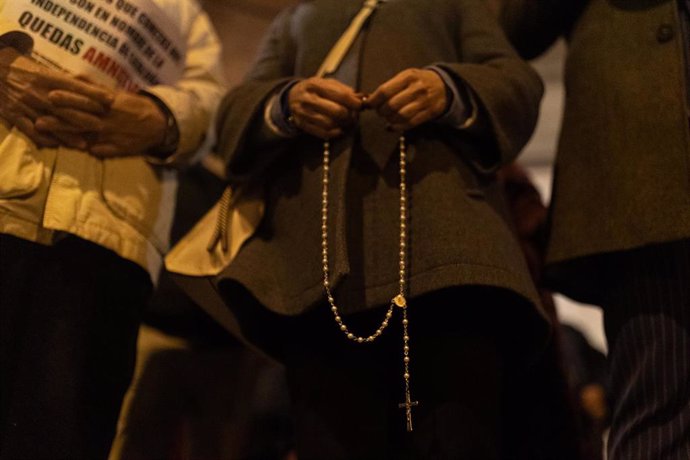 Archivo - Una mujer con un rosario durante una manifestación contra la amnistía frente a la sede del PSOE en Ferraz, a 13 de noviembre de 2023, en Madrid (España).