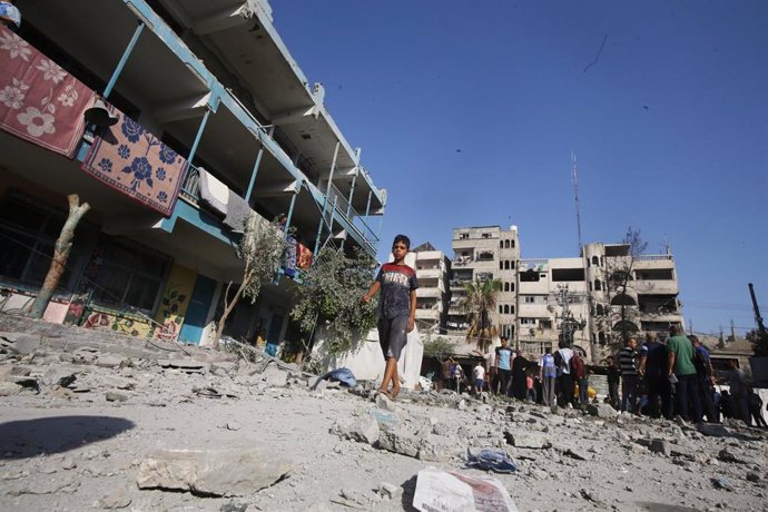 Palestinos en una escuela de la Agencia de Naciones Unidas para los Refugiados de Palestina en Oriente Próximo (UNRWA) bombardeada por el Ejército de Israel en el campamento de refugiados de Nuseirat, en el centro de la Franja de Gaza