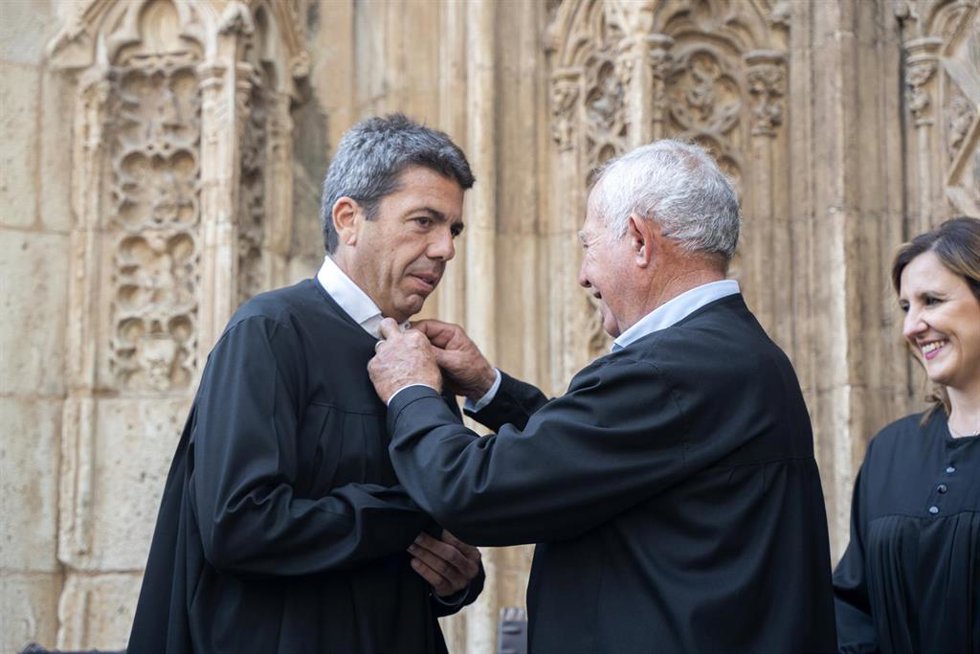 (I-D) El president de la Generalitat, Carlos Mazón, , durante el acto de entrega de la blusa de síndico de honor del Tribunal de las Aguas de la Vega de Valencia y la medalla de plata conmemorativa del milenario de esta institución