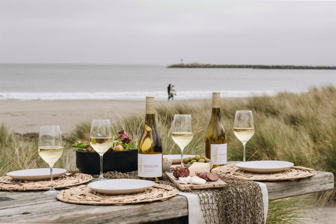 Mesa frente al mar con vinos y copas