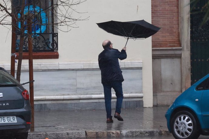 Archivo - Una persona se protege de la lluvia con su paraguas. A 9 de febrero de 2024, en Sevilla (Andalucía, España). La borrasca 'Karlotta' activa avisos por lluvia, viento y oleaje en todas las provincias andaluzas.