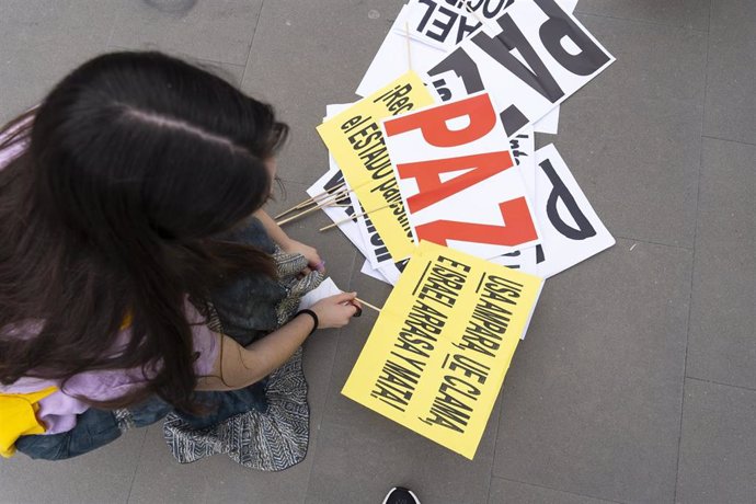 Una mujer prepara carteles durante una concentración propalestina