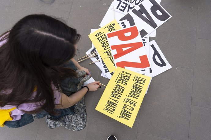 Una dona prepara cartells durant una concentració propalestina.