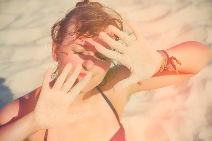 Archivo - Imagen de archivo de una mujer protegiéndose del sol en la playa.