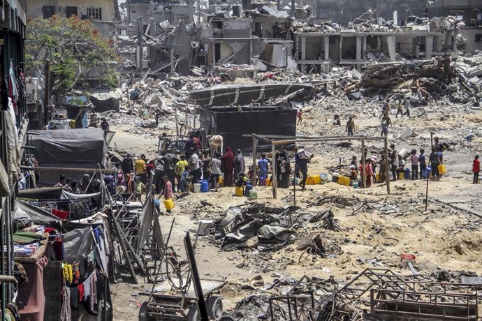 Un grupo de palestinos intenta obtener agua en el campamento de refugiados de Yabalia, en el norte de la Franja de Gaza, en medio de edificios destruidos por el Ejército de Israel (archivo)