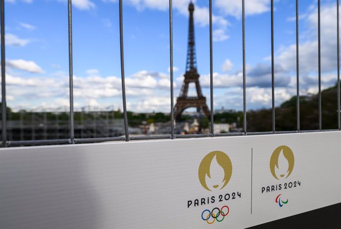 Archivo - FILED - 06 May 2024, France, Paris: The Olympic rings and the Paralympic Games logo can be seen on a sign on a construction fence in front of the Eiffel Tower. The Olympic Games and Paralympics take place in France this summer. Photo: Robert Mic