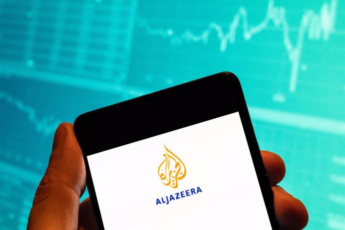 Archivo - February 15, 2023, China: In this photo illustration, the Qatar state-funded media network television channel and online newspaper Al Jazeera (AJ) logo seen displayed on a smartphone with an economic stock exchange index graph in the background.