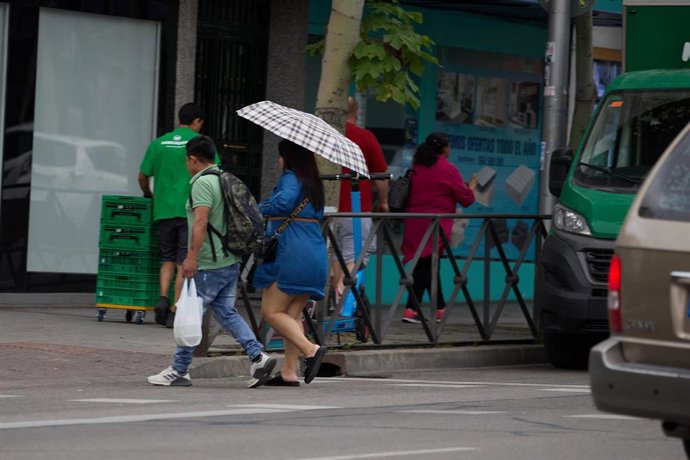 Dos personas se protegen de la lluvia con un paraguas, a 8 de junio de 2024, en Madrid (España). 