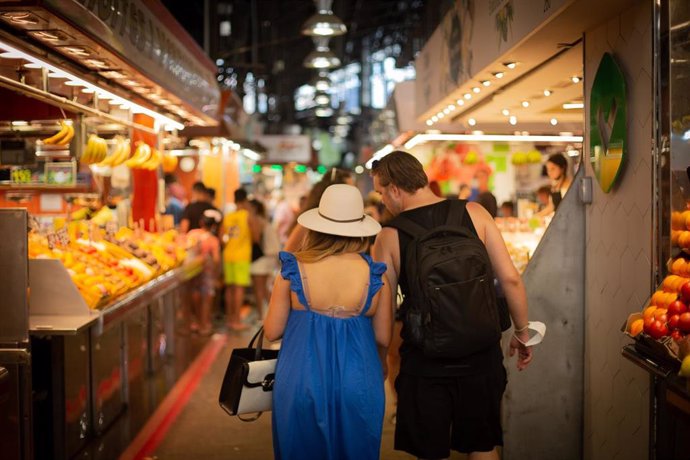 Archivo - Un hombre y una mujer pasean por el mercado de La Boquería, a 5 de agosto de 2021, en Barcelona, Cataluña, (España)