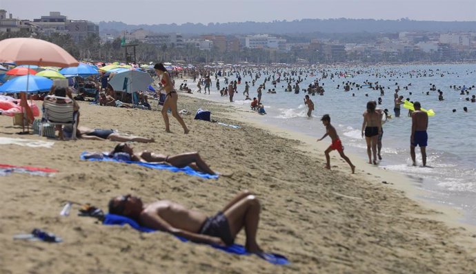 Archivo - 18 July 2023, Spain, Palma de Mallorca: People swim and sunbathe on the beach of Arenal amid a heatwave. 