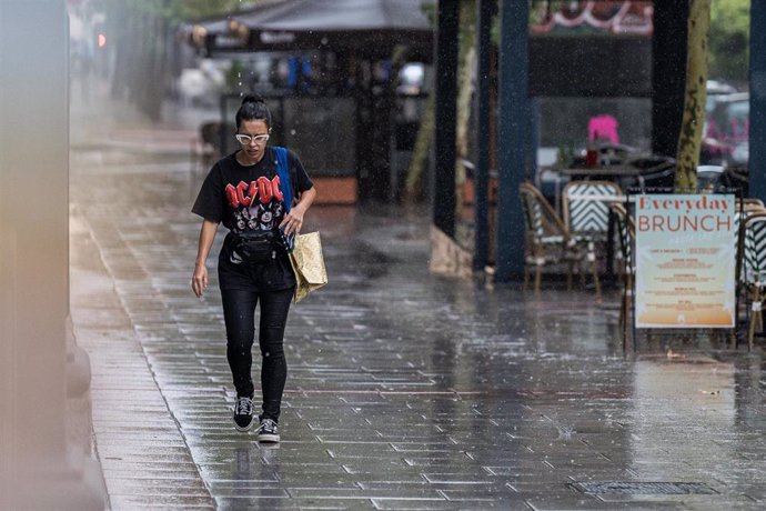 Archivo - Una mujer camina bajo la lluvia, a 3 de septiembre de 2023, en Madrid (España). 