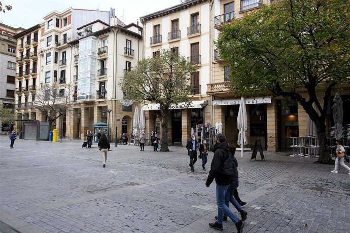 Archivo - Varias personas pasean por una calle de San Sebastián con establecimientos de pintxos 