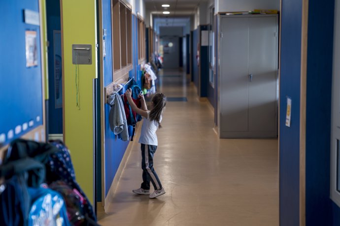 Una niña cuelga su mochila en un perchero durante una visita de la presidenta de la Comunidad de Madrid, Isabel Díaz Ayuso al Colegio público de Educación Infantil y Primaria San Juan Bautista con motivo de la inauguración del curso escolar 2023/2024, a 
