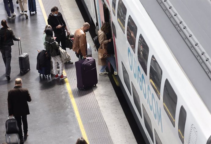 Archivo - Varias personas, con maletas, en el andén antes de coger un tren de alta velocidad, en el día en que arranca la operación salida de Semana Santa 2022, en la estación Madrid - Puerta de Atocha, a 8 de abril de 2022, en Madrid (España).  