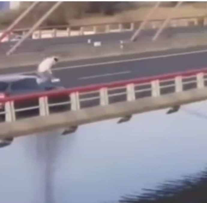 Archivo - Captura de un vídeo que circula en redes sociales y en el que se ve a un joven lanzarse al agua desde un coche que circula por Colindres