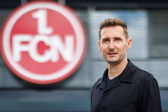 11 June 2024, Bavaria, Nürnberg: The new FC Nurnberg (FCN) coach Miroslav Klose (R) stands in front of the club logo. Klose takes over as coach at 1. FC Nürnberg. The former German international signs a two-year contract with the second division club. Pho