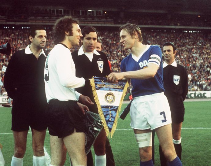 Archivo - FILED - 22 June 1974, Hamburg: West Germany's Franz Beckenbauer (L) and East Germany's Bernd Bransch (R) exchange pennants prior to the start of the 1974 FIFA World Cup Group A soccer matc between East Germany and West Germany at the Volksparkst