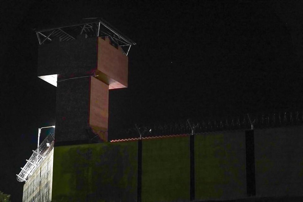 Archivo - Torre de vigilancia en una prisión de El Salvador mientras un convoy que transporta presos sale rumbo al CECOT