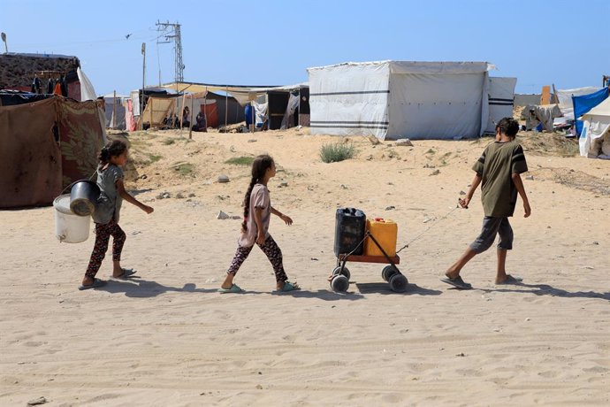 GAZA, June 10, 2024  -- Displaced children fetch water at al-Mawasi area in the southern Gaza Strip city of Khan Younis, on June 10, 2024. On May 7, the Israeli military expanded its operations in Rafah, directing over 1.5 million Palestinians to move to 