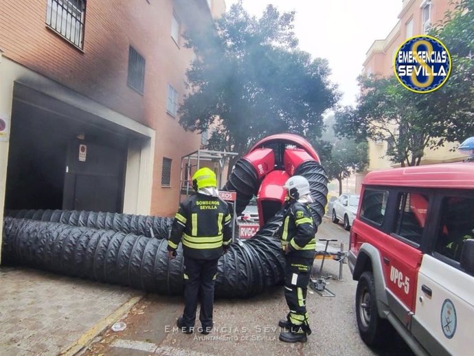 Bomberos actúan en un aparatoso incendio en el aparcamiento subterráneo de un edificio de viviendas de Pino Montano.