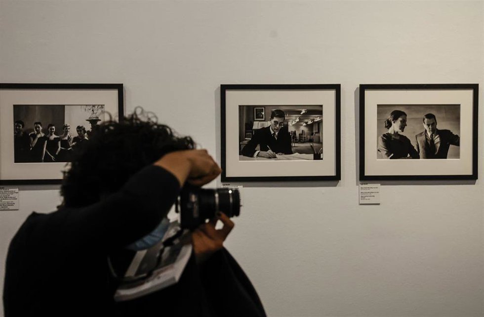 Archivo - Una persona fotografía imágenes de una muestra dedicada a las fotógrafas Eve Arnold, Inge Morath y Cristina García Rodero, de la Agencia Magnum Photos
