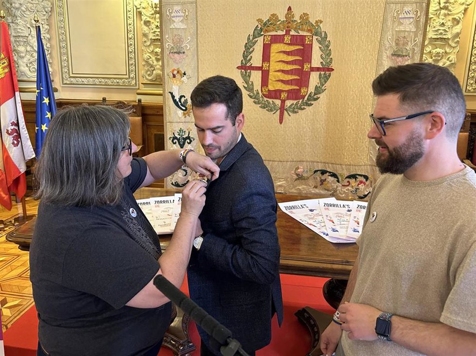 Representantes de la Fundación Triángulo colocan al concejal Rodrigo Nieto la chapa del 'Zorrilla's Fest'.