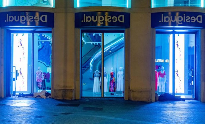 Archivo - Dos personas duermen a las puertas de una tienda durante la realización del censo de personas en situación de sinhogarismo llevado a cabo por la fundación Arrels, a 15 de junio de 2022, en Barcelona