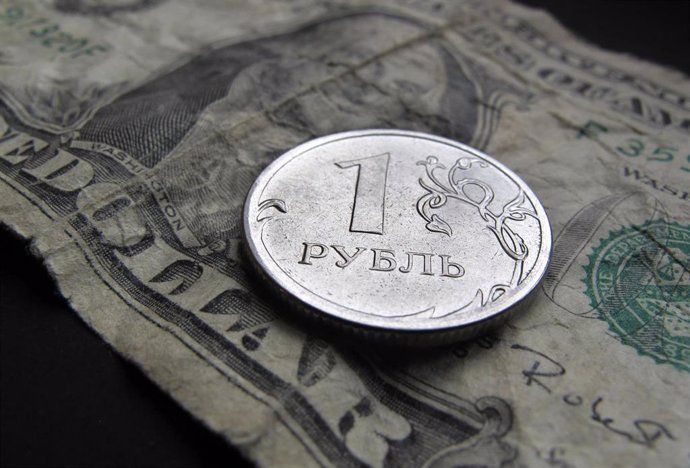 Archivo - FILED - 16 December 2014, Bavaria, Kaufbeuren: A Russian one-ruble coin placed on a one US dollar note. Photo: Karl-Josef Hildenbrand/dpa