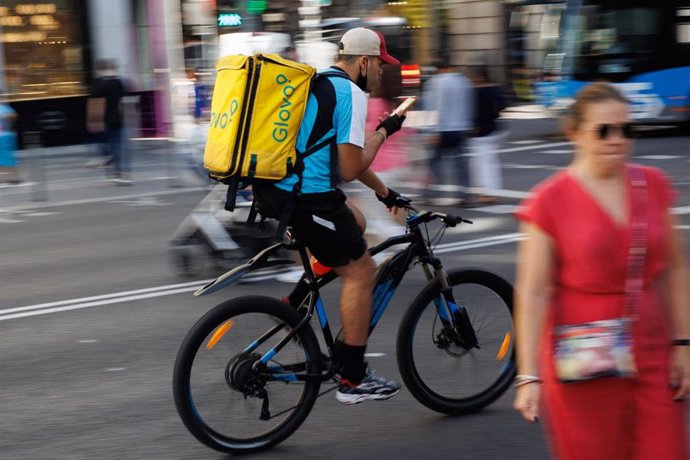 Archivo - Un repartidor de Glovo en bicicleta por una calle del centro de Madrid. 