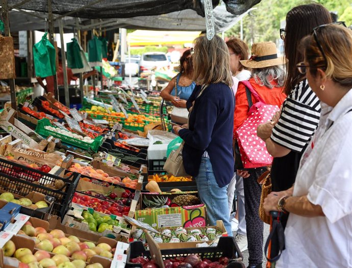 Diverses persones fan cua en un mercat