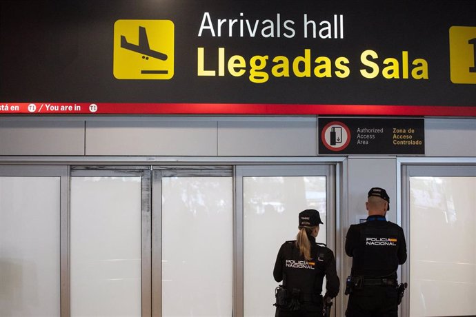 Archivo - Dos agentes de la Policía Nacional en la puerta de llegadas de la terminal T1 del Aeropuerto Adolfo Suárez Madrid Barajas