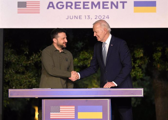 El presidente de EEUU, Joe Biden (d), y su homólogo de Ucrania, Volodimir Zelenski (i), tras la firma de un acuerdo de seguridad de diez años de duración durante la cumbre del G7 