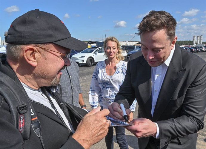 Archivo - 03 September 2020, Brandenburg, Gruenheide: Technology entrepreneur and CEO of SpaceX, Elon Musk (R) signs an autograph to a Tesla fan during his visit to the Tesla Gigafactory construction site in Gruenheide near Berlin, during his visit to Ger