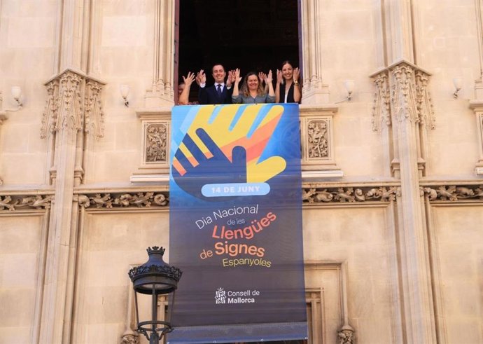 El presidente del Consell de Mallorca, Lloren Galmés, junto a la consellera de Cultura y Patrimonio, Antnia Roca, y la presidenta de la Asociación de Personas Sordas de Mallorca, Ana María Ruiz, en el despliegue de la pancarta.