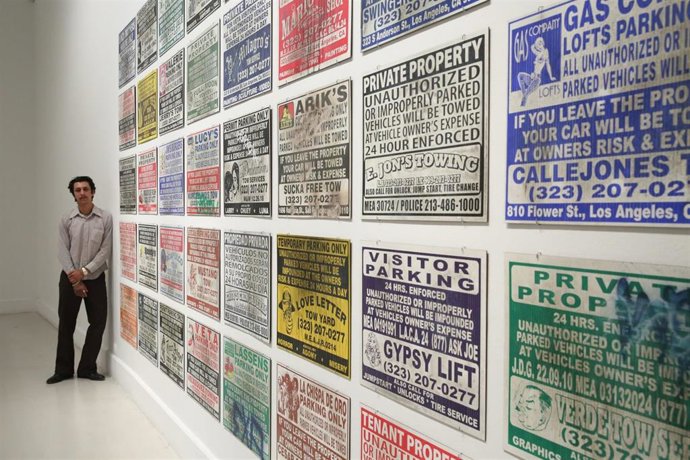 Ayala junto a 'Tow Signs', pinturas de carteles comúnmente encontrados en los aparcamientos en la Costa Oeste estadounidense.