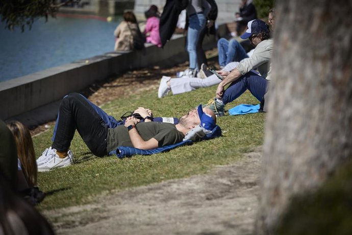 Archivo - Una persona toma el sol aprovechando las altas temperaturas, en el Parque del Retiro, a 11 de marzo de 2023, en Madrid (España). 