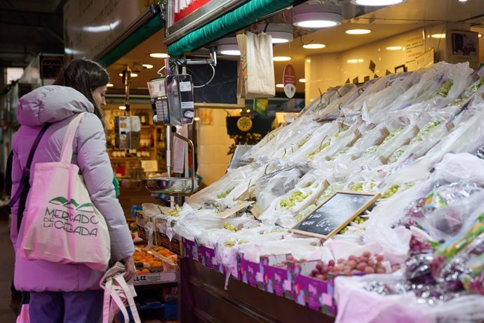 Archivo - Una mujer realiza sus últimas compras antes de la cena de Nochevieja en un mercado, a 31 de diciembre de 2023, en Madrid (España).