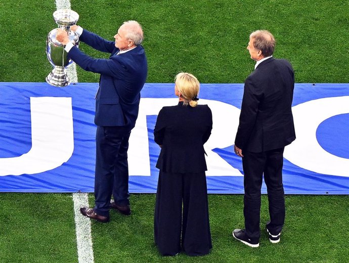 14 June 2024, Bavaria, Munich: Heidi Beckenbauer (C), widow of former national player and coach Franz Beckenbauer, presents the European Championship trophy accompanied by Bernard Dietz and Juergen Klinsmann (R), Germany's captains at the 1980 and 1996 Eu